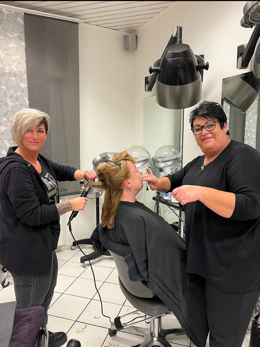 Zwei Stylistinnen von Salon Lora Hairstyle arbeiten gemeinsam an einer Kundin